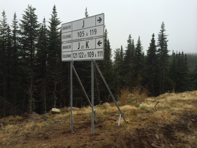Ensemble de panneaux de signalisation directionnelle pour chantier éolien, installés en milieu forestier isolé