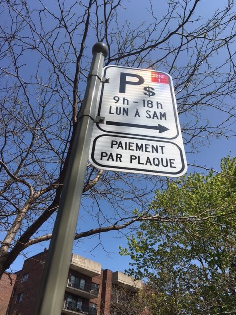 Panneau de stationnement payant par plaque — 9h à 18h, lundi au samedi — installé sur poteau en zone urbaine